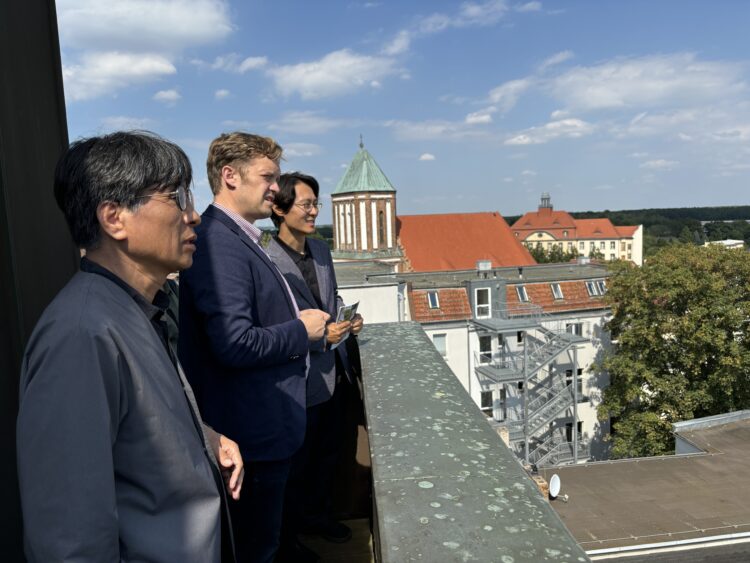 Blick über die Dächer von Senftenberg vom Rathausturm aus: Bürgermeister Andreas Pfeiffer (Mitte) mit  dem südkoreanischen Anwalt und Politiker Lee Tahney und dem Journalisten Dr. Lee Changgon. (Bild: Andrea Budich)