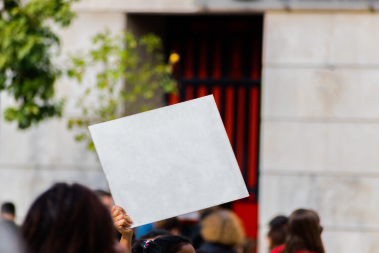 Sign with white copy space for your text hold by young millennial activist in strike